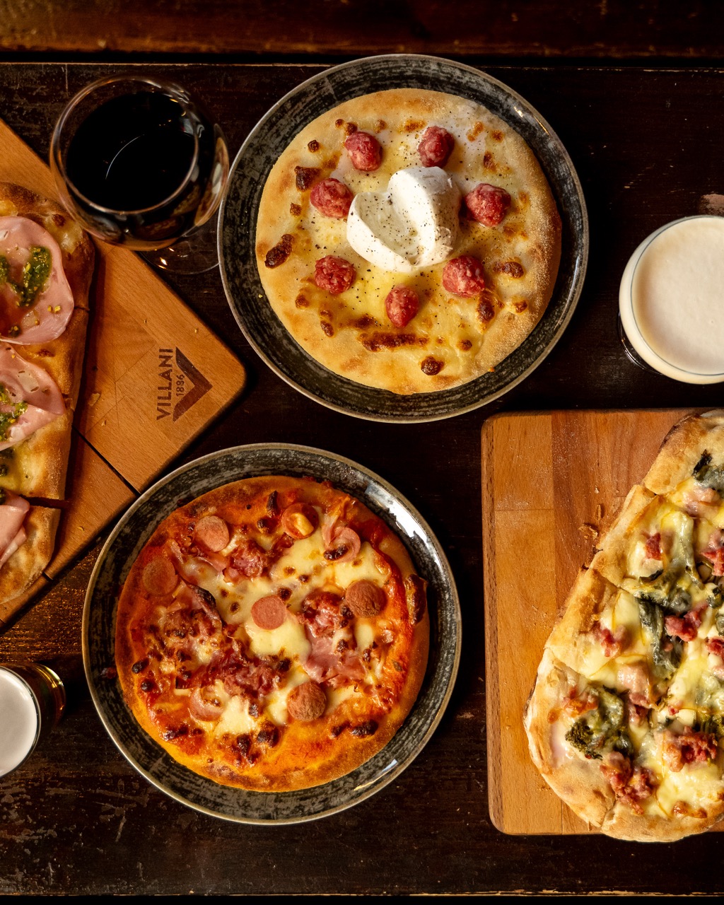 Pizze al tegamino e birre servite in tavola all'Enfant Prodige